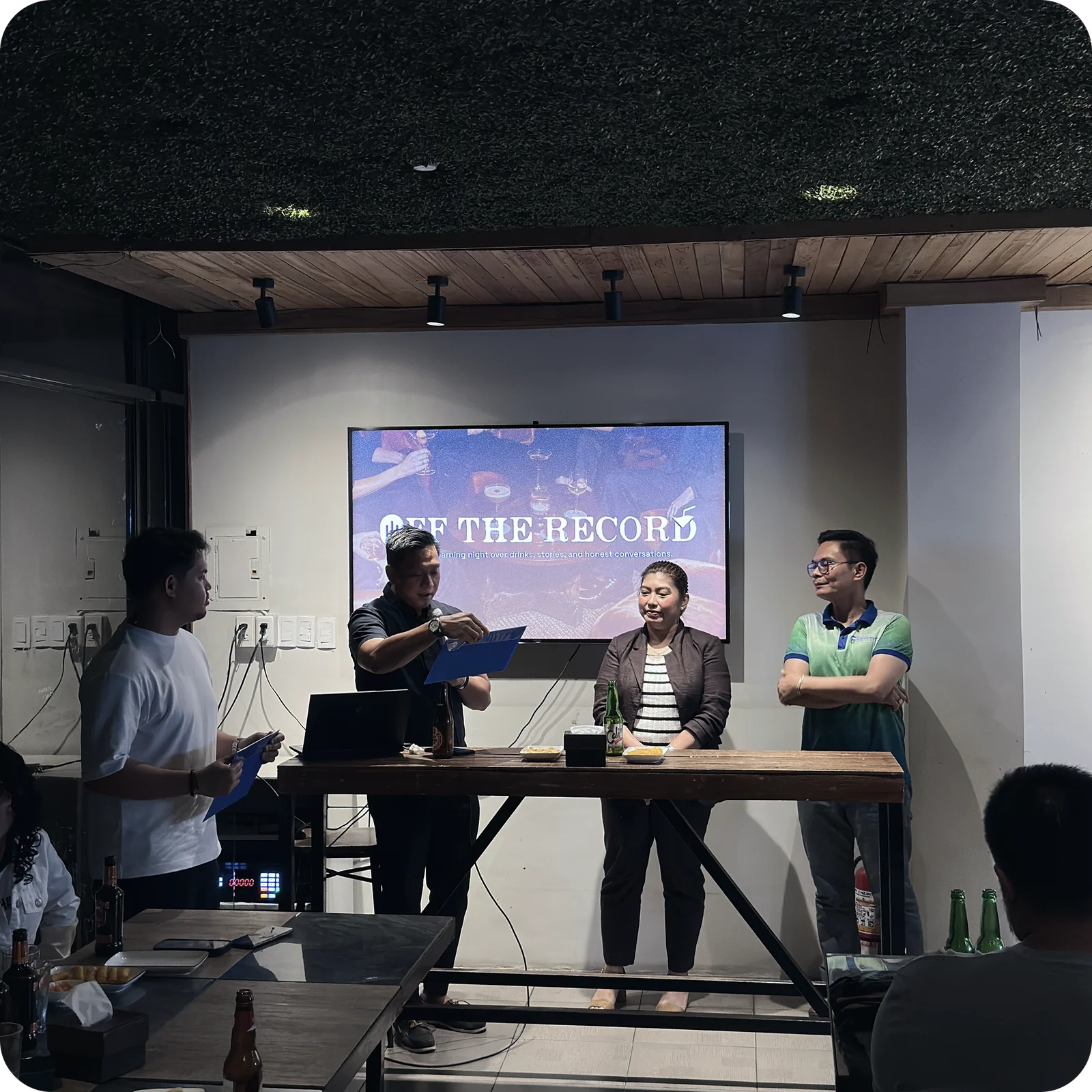Off the Record — speakers on stage with the branded screen