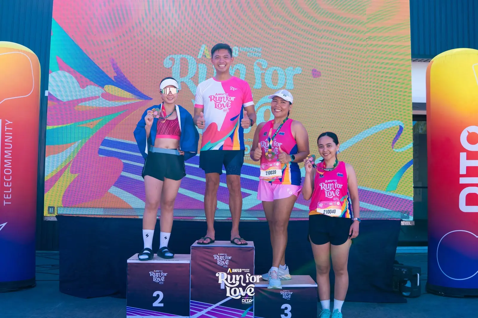 Run for Love — 21K category winners on the awarding podium with heart medals and the branded LED backdrop